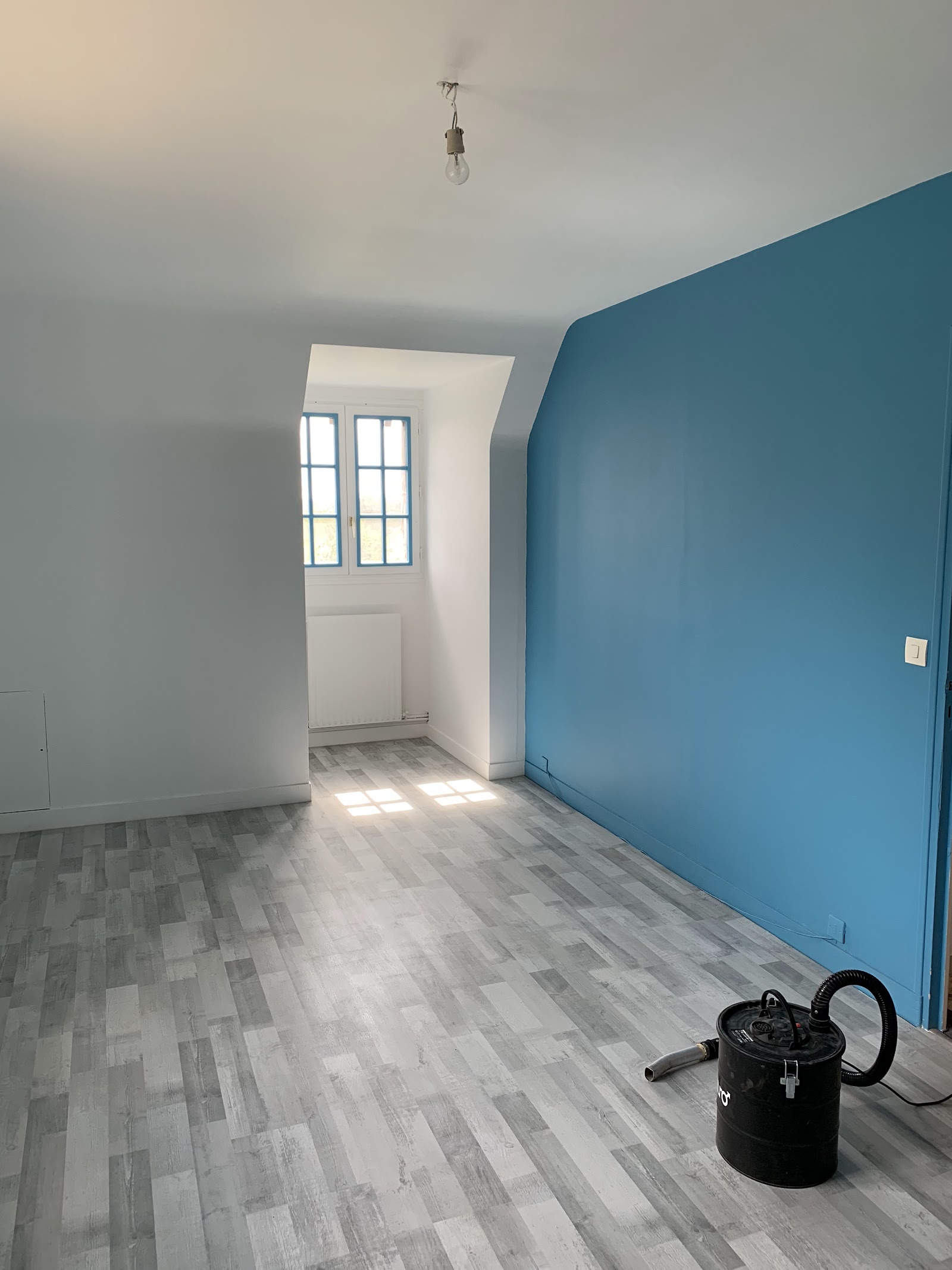 Peinture intérieure et pose de revêtement de sol dans une chambre.
