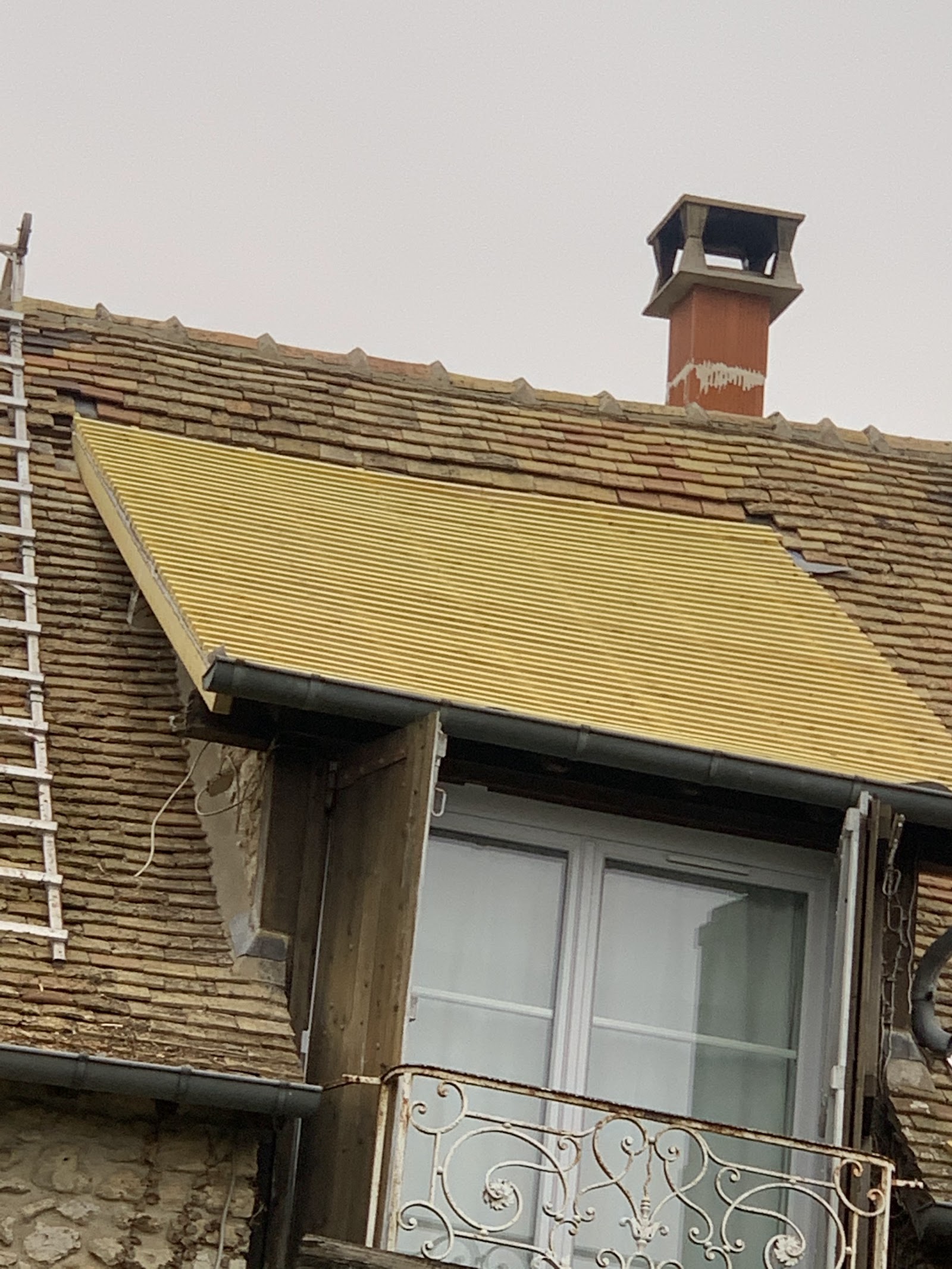 Rénovation de toiture au-dessus d’une lucarne.